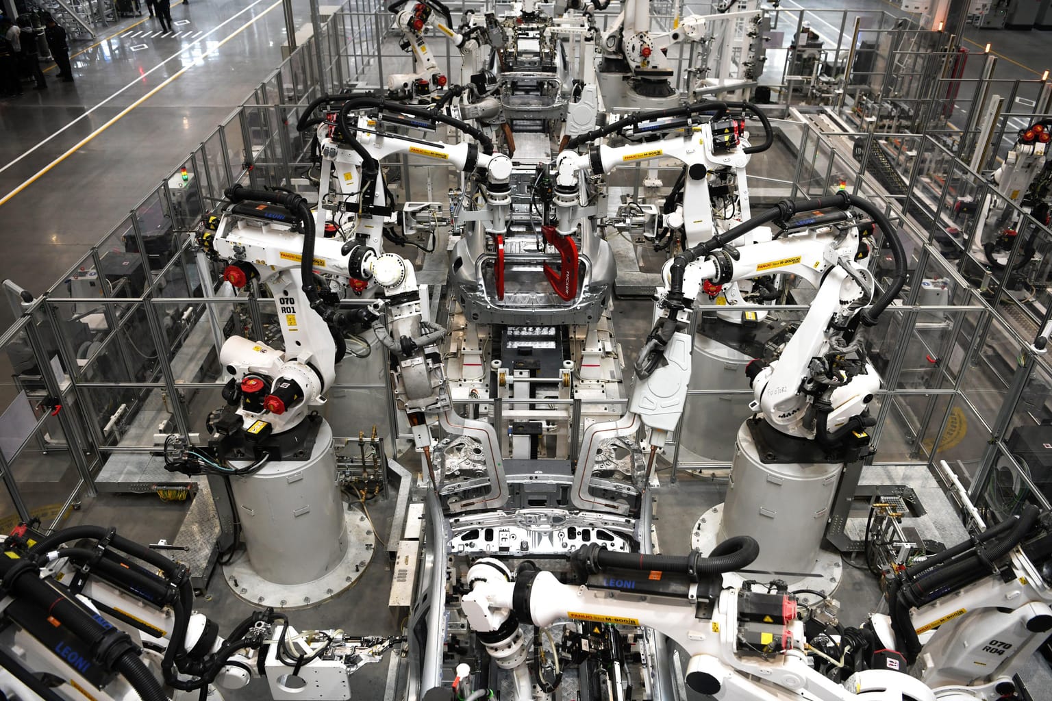 Multiple robot arms working around a vehicle body at Xiaomi's factory